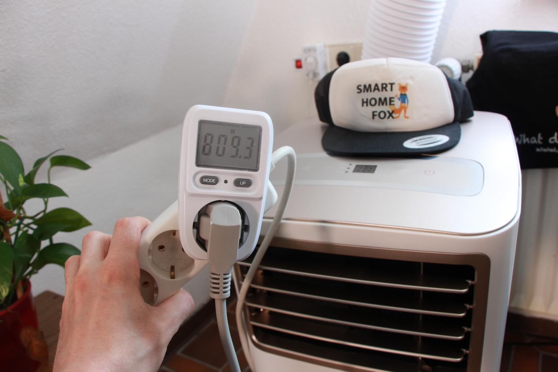 Der Stromverbrauch einer mobilen Klimaanlage wird im Test gemessen und das Messgerät zeigt einen Verrbauch von 809 Watt an.